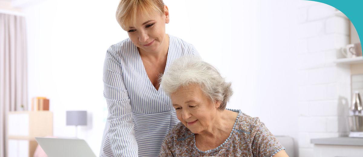 Aged care worker and older lady working on a computer