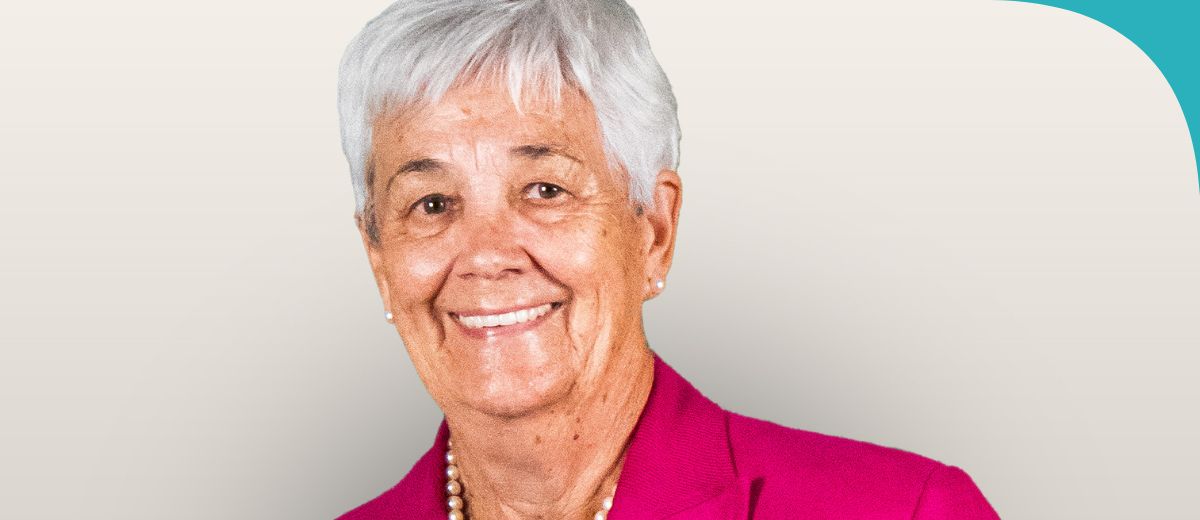 A lady in a red blazer smiling